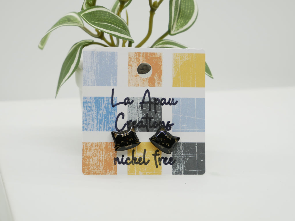 Black cat-shaped earrings on a colorful card with 'La Apeau Creations' branding.