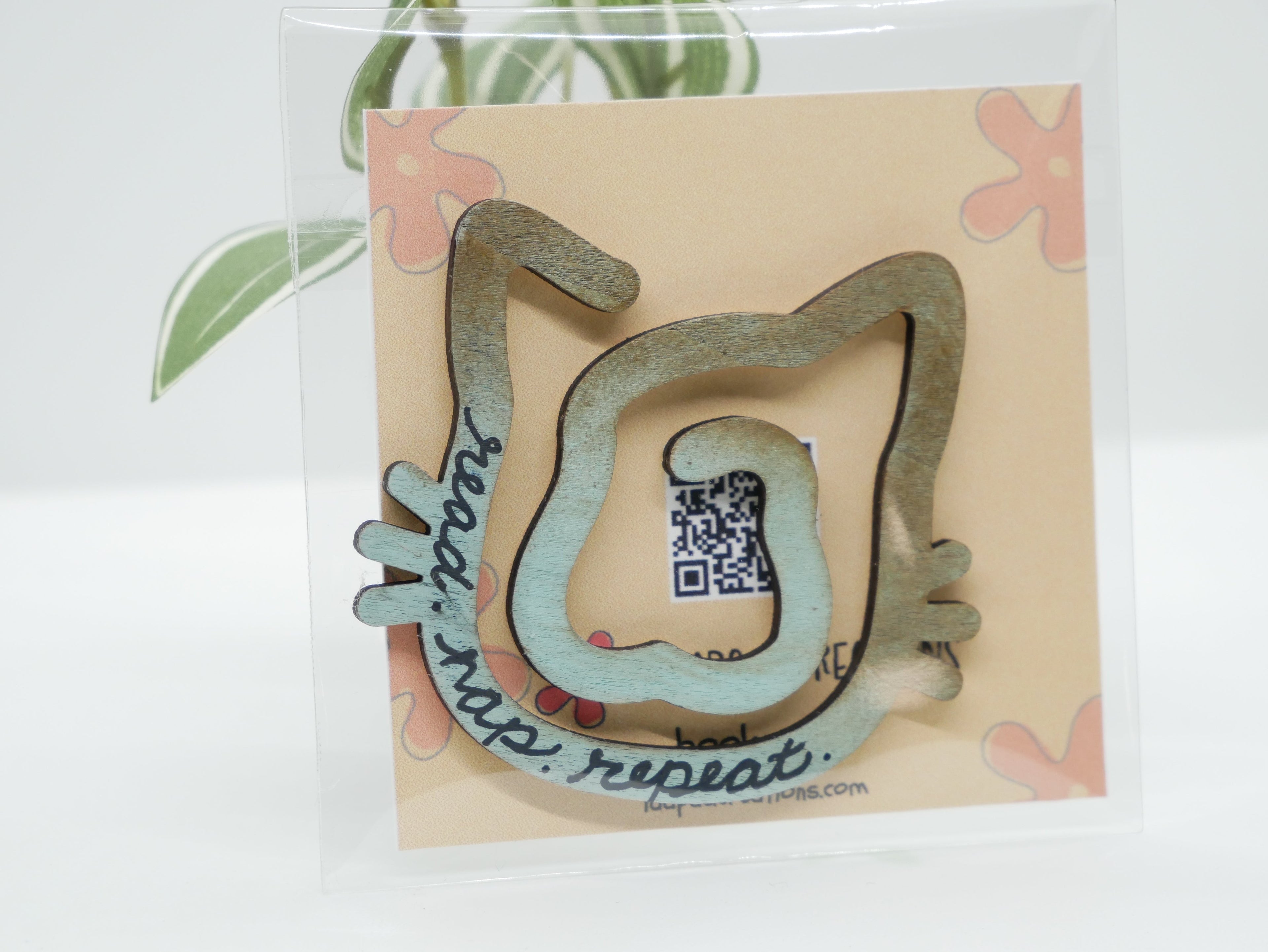 La Apau Creations wooden cat bookmark with ombre brown to blue gradient and read nap repeat text in clear packaging