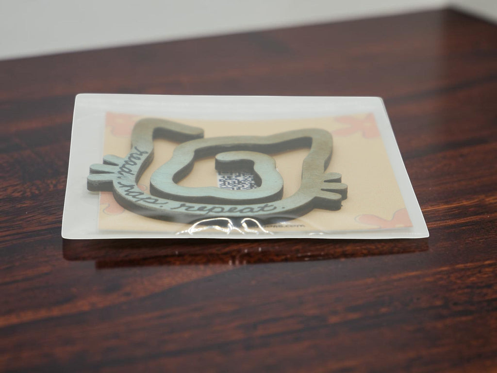 La Apau Creations wooden cat bookmark with read nap repeat text in an ombre brown to blue finish in packaging
