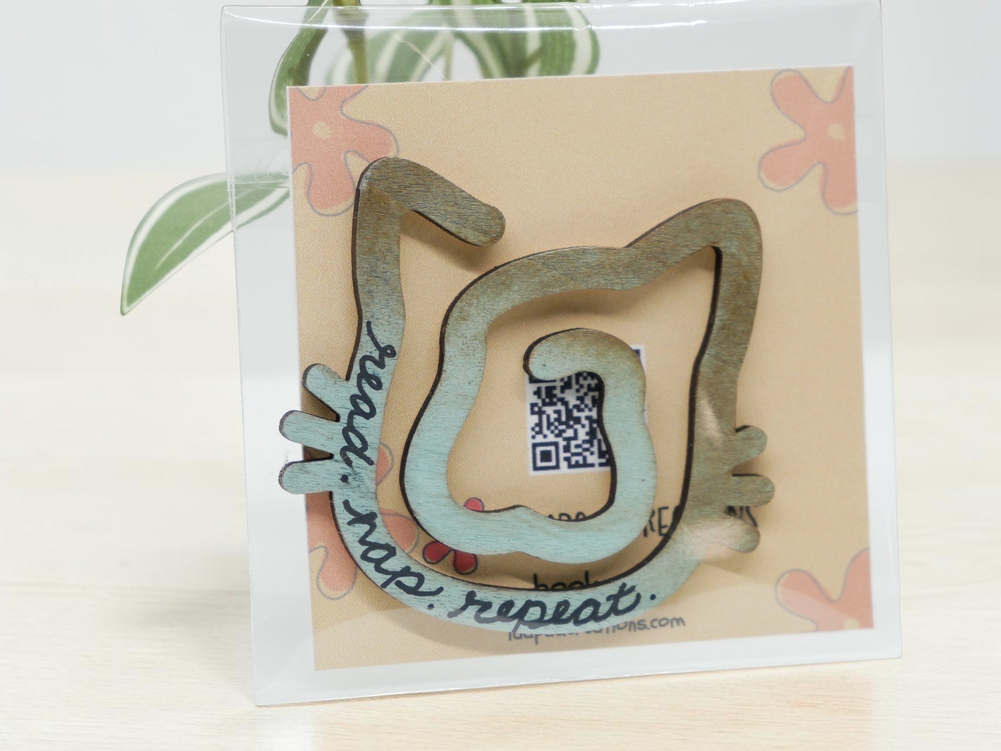 La Apau Creations wooden cat bookmark with ombre brown to blue gradient and read nap repeat text in clear packaging